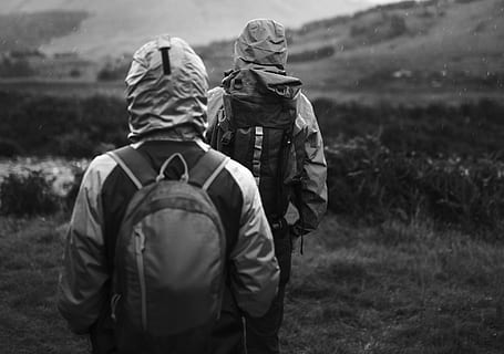 Due, persone, zaini, escursioni a piedi, verde, fotografia di campo in scala di grigi, indietro, zaino, bianco e nero, nuvoloso, coppia, luce del giorno, ambiente, erba, escursione, giacca, paesaggio, montagne, naturale, natura, attrezzatura, piovere, panoramico, alberi, il trekking, a piedi, indossare, persone reali, uomini, terra, retrovisore, due persone, campo, giorno, capi di abbigliamento, attività di svago, solidarieta, pianta, concentrarsi sulle conoscenze acquisite, adulto, abbigliamento casual, stili di vita, all'aperto, in piedi, vestiti caldi, cappuccio - abbigliamento, 4K, CC0, dominio pubblico, privo di copyright