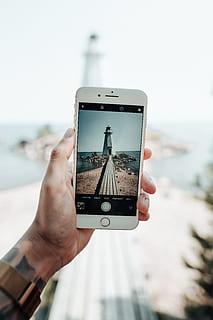 bianca, faro, Telefono, dispositivo, schermo, i phone, scattare foto, mano, fotografo, istantanea, vista, costa, spiaggia, riva, molo, passerella, foto, sensazione, estate, lago, acqua, cellulare, smart phone, all'aperto, detenzione, mare, viaggio, mano umana, Fotografare, tecnologia, vacanze, macchina fotografica - attrezzatura fotografica, tecnologia wireless, mobilità, persone, destinazioni di viaggio, turismo, stili di vita, uomini, turista, persone che viaggiano, temi fotografici, comunicazione, donne, touch screen, fotografia, editoriale, dispositivo di informazione portatile, giorno, 5K, CC0, dominio pubblico, privo di copyright