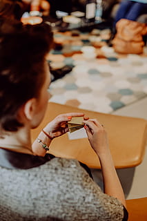women, folding, sheet, paper, making, origami, creative, workshop, handmade, artwork, craft, japan, real people, holding, one person, lifestyles, indoors, adult, leisure activity, table, sitting, business, human hand, human body part, hand, food and drink, casual clothing, selective focus, focus on foreground, portrait, 4K, CC0, public domain, royalty free