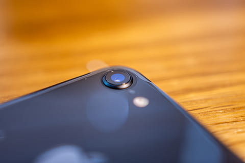telefoon, lens, camera, iphone, macro, zoom, hout, detailopname, selectieve aandacht, geen mensen, binnenshuis, technologie, hout - materiaal, verbinding, enkel object, stilleven, communicatie, tafel, controle, afstandsbediening, focus op de voorgrond, Draadloze technologie, extreem dichtbij, defocused, 5K, CC0, publiek domein, royaltyvrij