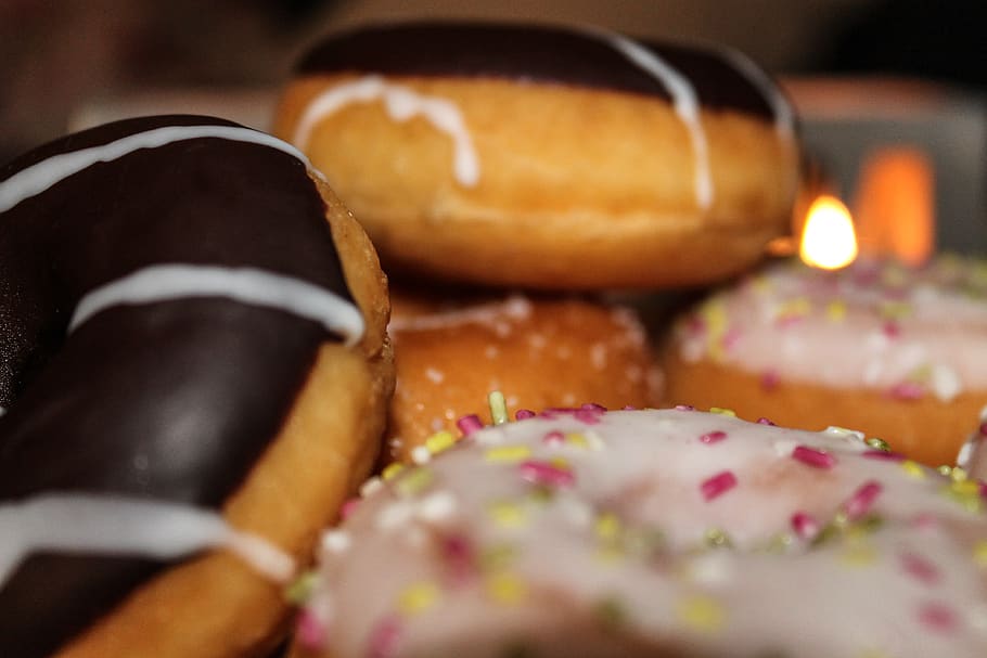 verschiedene Donuts, Essen und Trinken, Lebensmittel, selektiver Fokus, Nahansicht, Frische, drinnen, ungesunde Ernährung, fertig für den Verzehr, Genuss, eine Person, Süßes Essen, Fokus auf den Vordergrund, gebacken, Dessert, Brot, Süss, Studioaufnahme, Feier, Versuchung, Snack, 4K