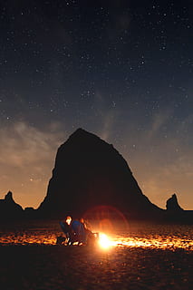 photo, couple, sitting, front, bonfire, mountain, haystack rock, fire, star, coast, cloud, person, people, chair, campfire, sky, beach, sand, rock, summer, lifestyle, night, dark, cannon beach, oregon, star - Space, nature, landscape, astronomy, outdoors, scenics, galaxy, desert, travel, sunset, adventure, silhouette, light - Natural Phenomenon, milky Way, space, beauty In Nature, exploration, hiking, rock - Object, backgrounds, black Color, camping, vacations, dusk, glowing, red, travel Destinations, tent, sun, orange Color, sunlight, 5K, CC0, public domain, royalty free