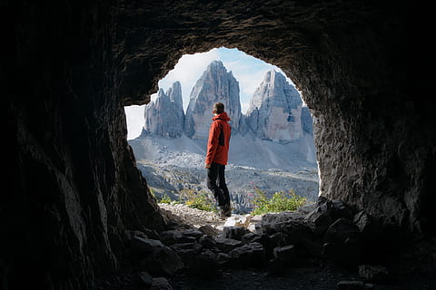 homem, vermelho, Jaqueta, de pé, lado de fora, caverna, frente, três, montanhas, fundo, nuvens, luz do dia, dia, Alto, panorama, Pico da montanha, natureza, pessoa, fotografia, rochas, cênico, céu, Rocha, rock - objeto, uma pessoa, sólido, montanha, pessoas reais, atividade de lazer, comprimento total, estilos de vida, formação rochosa, beleza na natureza, adulto jovem, scenics - natureza, aventura, geologia, roupa casual, cadeia de montanhas, ao ar livre, formação, 4K, CC0, domínio público, royalty free