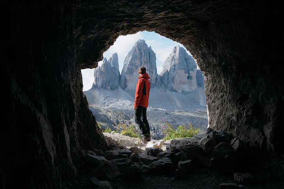 home, vermell, jaqueta, de peu, fora, cova, frontal, tres, muntanyes, fons, núvols, la llum del dia, durant el dia, alt, paisatge, cim de muntanya, naturalesa, persona, fotografia, roques, escènic, cel, rock, rock - object, una persona, sòlid, muntanya, persones reals, activitat d'oci, longitud completa, estils de vida, formació de roca, dia, bellesa a la natura, adult jove, escenics - natura, aventura, geologia, roba casual, Serra, a l'aire lliure, formació, 4K