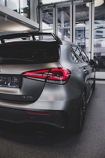 gray 5-door hatchback, mode of transportation, land vehicle, transportation, motor vehicle, car, stationary, no people, day, travel, indoors, red, black color, architecture, sports car, parking, showroom, parking lot, close-up, automobile industry, wheel, luxury, garage, 5K, CC0, public domain, royalty free