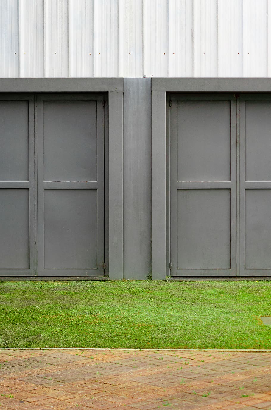 grå dør, arkitektur, bygning, konstruktion, dagslys, design, døre, døråbning, tom, indgang, ydre, facade, garage, græs, hus, moderne arkitektur, udendørs, bygget struktur, bygning udvendig, ingen mennesker, dag, grøn farve, dør, lukket, plante, sikkerhed, træ - materiale, murbygningsfunktion, Mark, natur, beskyttelse, 2K