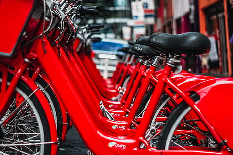 red cruiser bicycles, bicycles, parked, red, land vehicle, mode of transportation, transportation, bicycle, stationary, in a row, wheel, city, no people, focus on foreground, close-up, day, parking, metal, rickshaw, outdoors, street, travel, motorcycle, spoke, 5K, CC0, public domain, royalty free