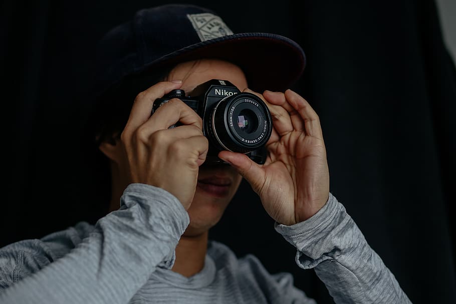 muž, přijímání, fotografie, použitím, Fotoaparát, osoba, člověk, elektronika, prst, oblečení, oděv, fotograf, fotografování, kamerové čočky, digitální fotoaparát, videokamera, čepice, klávesnice, víčko, Zobrazit, monitor, LCD obrazovka, obrazovka, fotoaparát - fotografické vybavení, hospodářství, focení, technologie, jedna osoba, fotografická témata, fotografické vybavení, aktivita, střela do hlavy, černé pozadí, skutečných lidí, dospělý, uvnitř, portrét, objektiv - optický přístroj, čelní pohled, slr fotoaparát, digitální jednooká zrcadlovka, 4K