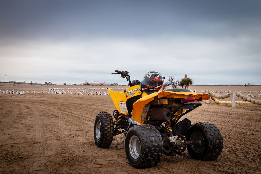 atv groc, transport, una persona, manera de transport, casc, dia, barreteria, cel, naturalesa, terra, persones reals, vehicle terrestre, industria de la construcció, brutícia, núvol - cel, moviment, a l'aire lliure, moto, seguretat, maquinària, casc protector, 5K