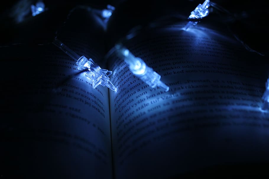 string lights, book, dark, illuminated, light, lights, page, words, paper, close-up, blue, human body part, arts culture and entertainment, selective focus, people, indoors, light - natural phenomenon, night, studio shot, body part, communication, music, text, data, education, high angle view, 2K